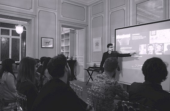 Un groupe de personne regarde Thomas Cerigny présentant le site sur un écran